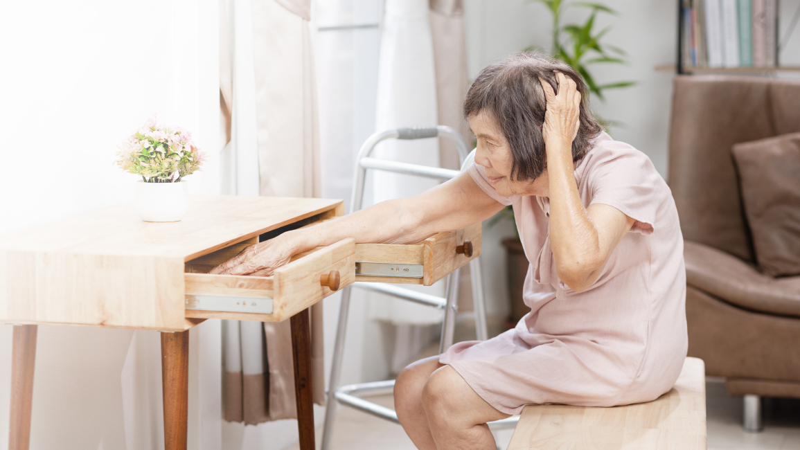 Elderly woman forgetting where she placed an item, one of the symptoms of normal age-related memory loss, which can worsen into dementia.